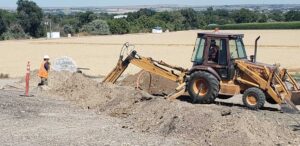 Farmers construction works digging to lay cable